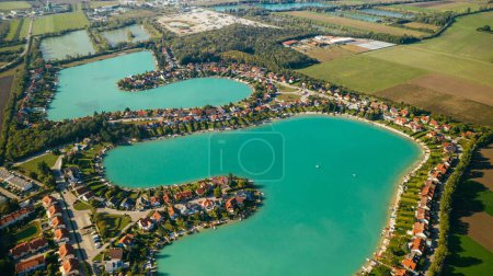 Téléchargez les photos : Vue par drone des plans d'eau entourés de verdure et de bâtiments à Oberwaltersdorf, Autriche - en image libre de droit