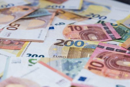 Foto de Un primer plano de una gran cantidad de billetes en euros esparcidos sobre la mesa blanca - Imagen libre de derechos