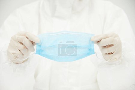 Photo for A close-up of a doctor holding a single face mask - Royalty Free Image