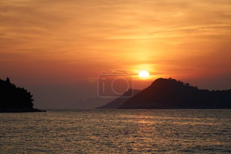 Téléchargez les photos : Une vue panoramique sur un coucher de soleil sur les collines et un lac - en image libre de droit