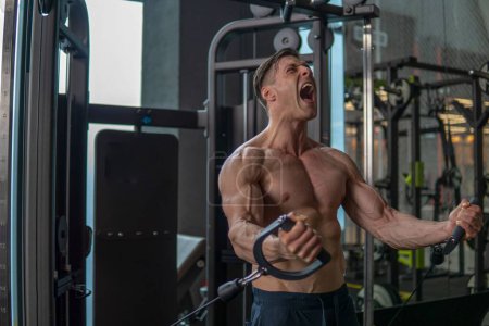 Foto de Un hombre caucásico muscular haciendo ejercicios en el gimnasio - Imagen libre de derechos
