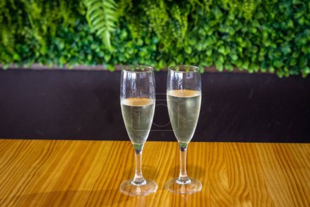 A closeup shot of two glasses of prosecco placed on a wooden table