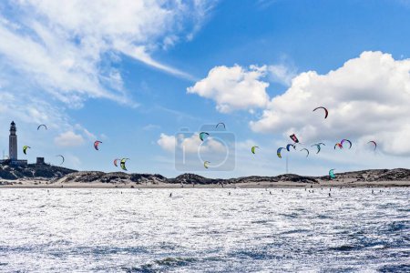 Téléchargez les photos : Une vue panoramique de la plage de Los Canos avec un peuple pratiquant le kitesurf sous le ciel lumineux - en image libre de droit