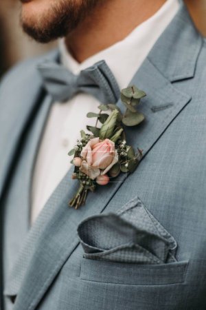 Photo for A vertical closeup of a bridegroom with a flower on the costume, blurred background - Royalty Free Image