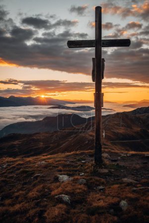 Foto de Una cruz con hermosas montañas al fondo durante la puesta de sol en el Tirol del Sur - Imagen libre de derechos