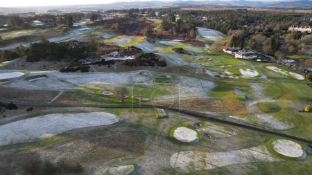 Téléchargez les photos : Vue aérienne d'un parcours de golf Gleneagles le long de la route rurale, par une journée ensoleillée, avec une forêt en arrière-plan - en image libre de droit