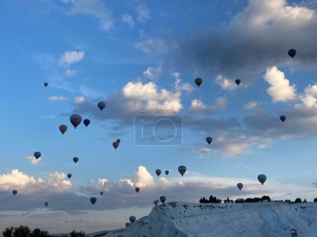 Téléchargez les photos : Un plan panoramique de montgolfières dans le ciel bleu au-dessus d'une montagne couverte de neige - en image libre de droit
