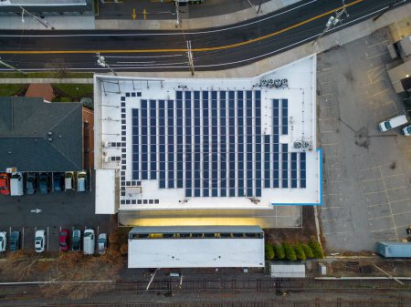 Photo for An aerial view of an office building with solar panels on the roof on a cloudy morning - Royalty Free Image