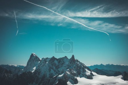 Foto de Una toma aérea de una montaña rocosa cubierta de nieve bajo el cielo y rutas de avión - Imagen libre de derechos