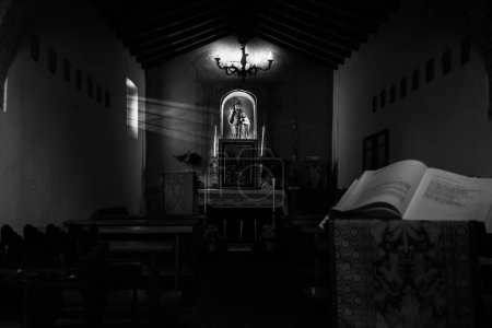Photo for A grayscale inside a church building with an opened book in front and icons in the background - Royalty Free Image
