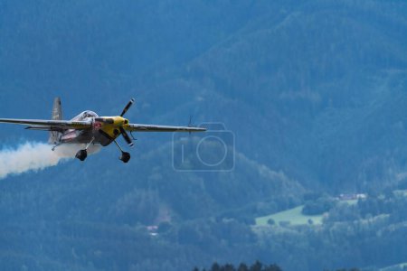 Téléchargez les photos : L'avion Red Bull en vol avec une traînée de fumée - en image libre de droit