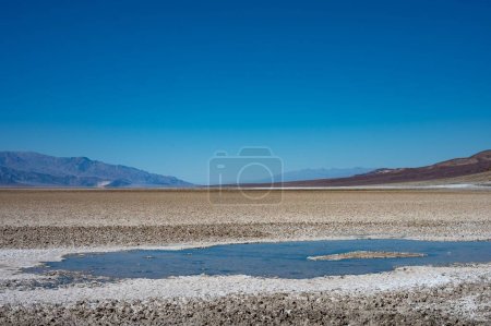 Téléchargez les photos : Flaque d'eau ou mirage d'eau dans le désert chaud de Mojave, horizon - en image libre de droit