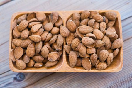Photo for Almonds in bowl, almonds on wooden background roasted almond for snack - Royalty Free Image
