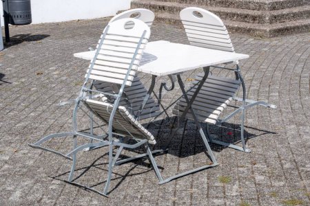 Photo for A set of old fashioned white chairs and a table set outdoors under the sunlight - Royalty Free Image