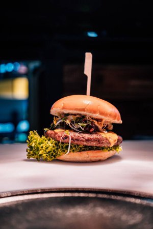 Photo for A vertical closeup of a tasty burger on the table. - Royalty Free Image