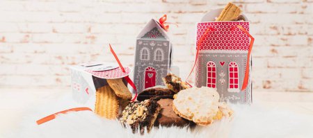 Téléchargez les photos : Biscuits de Noël faits maison élégamment et durablement emballés dans des boîtes en carton sous forme de maisons. - en image libre de droit