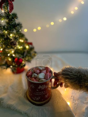 Téléchargez les photos : Un plan grand angle de tasse de Noël pleine de guimauves avec un arbre de Noël sur le fond flou - en image libre de droit