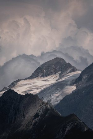 Foto de Un plano vertical de los nevados Alpes austríacos rocosos bajo un cielo azul brillante - Imagen libre de derechos