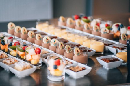 Téléchargez les photos : Un gros plan de différents desserts dans la ligne du buffet pour une fête de mariage - en image libre de droit