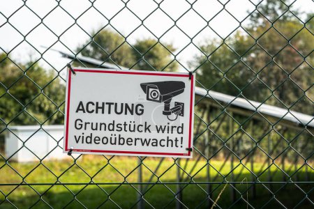 Foto de Una cerca con un letrero alemán: Atención, la propiedad está bajo videovigilancia! - Imagen libre de derechos