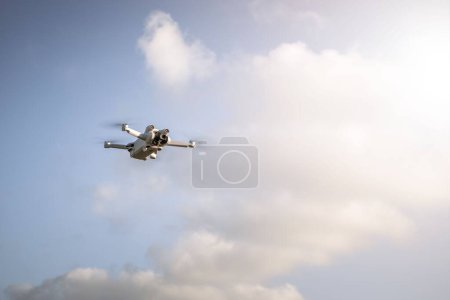 Photo for A white quadcopter flying in the sky on a sunny day - Royalty Free Image