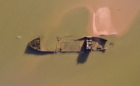 Foto de Una vista aérea de un dron de un barco hundido abandonado en un agua sucia - Imagen libre de derechos