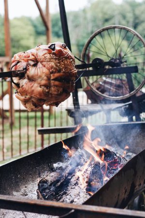 Foto de Un primer plano de carne asada en un asador con fuego en el fondo. - Imagen libre de derechos