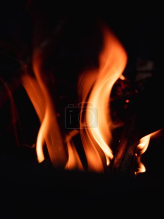 Foto de Llamas naranjas y amarillas envuelven la madera en el fuego - Imagen libre de derechos