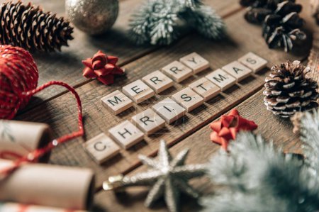 Téléchargez les photos : Un design de "Joyeux Noël" sur le fond en bois avec des décorations autour - en image libre de droit
