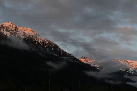 Foto de Una vista panorámica del paisaje de los picos de montaña cubiertos de nieve en un día nublado de invierno - Imagen libre de derechos