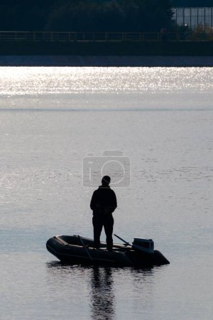 Photo for A man standing on a boat in the middle of a lake - Royalty Free Image