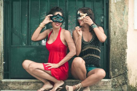 Foto de Un selectivo de dos hembras con máscaras de carnaval contra una puerta - Imagen libre de derechos