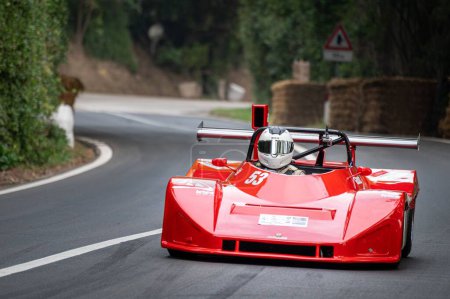 Téléchargez les photos : Une Ferrari rouge sur la route dans le parc de San Bartolo. Pesaro, Italie. - en image libre de droit