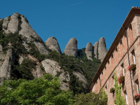Foto de La Abadía de Montserrat en la montaña de Montserrat en Cataluña, España con árboles - Imagen libre de derechos
