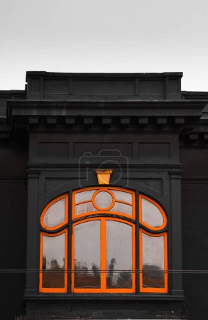 Foto de Vista vertical detallada de una ventana de marco naranja de un edificio negro - Imagen libre de derechos
