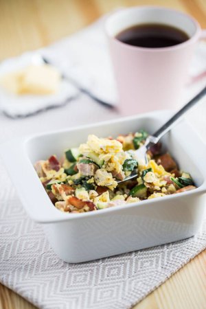Téléchargez les photos : Un plan vertical de la belle casserole de petit déjeuner dans le bol blanc à côté d'une tasse de café et des tranches de beurre - en image libre de droit