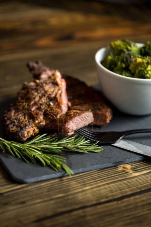 Téléchargez les photos : Un steak de boeuf et un bol de brocolis sur une planche - en image libre de droit