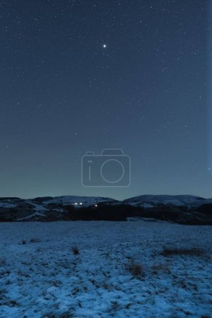 Photo for A vertical shot of the beautiful starry sky with the Milky Way above the snow-covered field and - Royalty Free Image