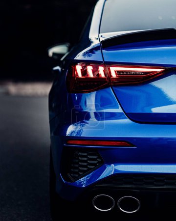 Foto de Una vista trasera de un coche deportivo azul brillante luces con fondo borroso, tiro vertical - Imagen libre de derechos