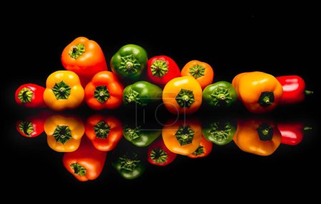 Photo for A closeup shot of colorful peppers isolated against the black background with reflections - Royalty Free Image