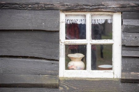 Téléchargez les photos : La vue d'une fenêtre dans le mur de bois d'un vieux bâtiment - en image libre de droit