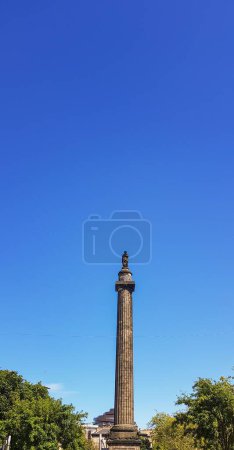 Photo for A low-angle vertical view of the ancient Melville Monument in the presence of lush trees and a clear sky - Royalty Free Image