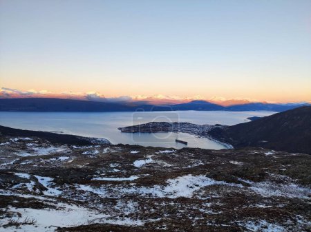 Foto de Un paisaje pintoresco del mar congelado rodeado de picos de montaña en un frío día de invierno - Imagen libre de derechos