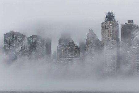Photo for A scenic view of New York City with skyscrapers and modern buildings covered in fog - Royalty Free Image