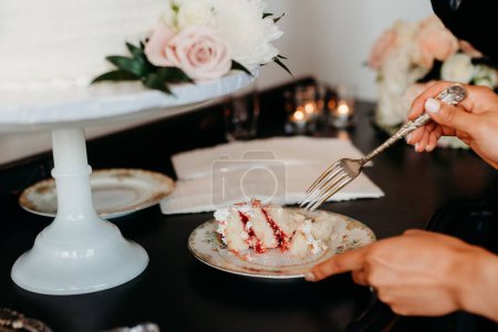Photo for The bride and the bridegroom slicing the wedding cake during the marriage celebration event - Royalty Free Image
