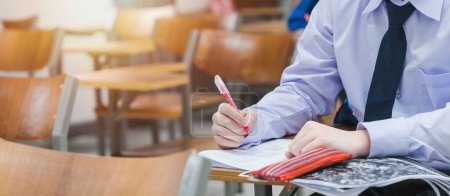 Foto de Una foto panorámica de un estudiante universitario escribiendo en los exámenes finales en el aula - Imagen libre de derechos