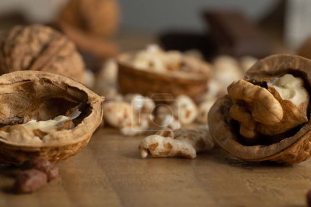 Foto de Un primer plano de nueces y chocolate repartido sobre la mesa de madera - Imagen libre de derechos