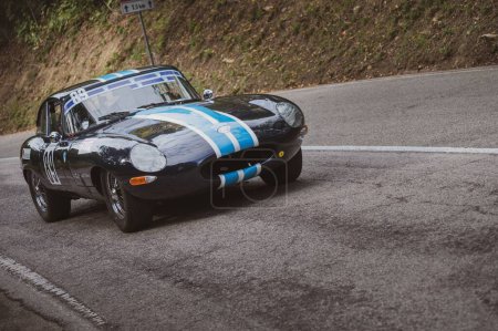 Téléchargez les photos : Une voiture de course légère Jaguar E-Type 1963 noire sur la route dans le parc San Bartolo. Pesaro, Italie. - en image libre de droit