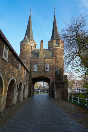 Photo for A cobblestone path leading into the eastern gate or Oospoort in Delft, Netherlands with high gothic towers - Royalty Free Image