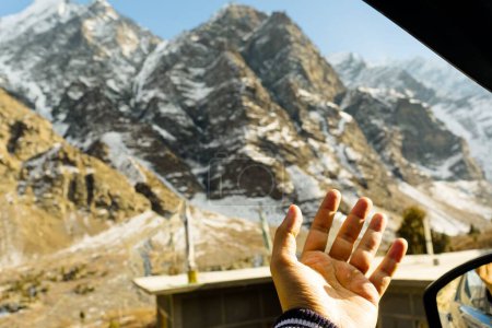 Téléchargez les photos : Un homme conducteur sentant le vent à travers ses mains dans la campagne - en image libre de droit